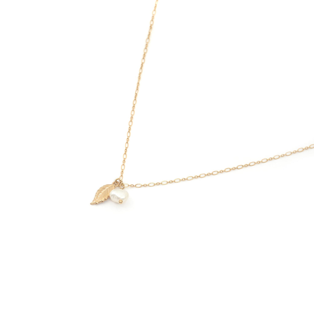 collier pendentif plume et perle d'au douce sur fond blanc