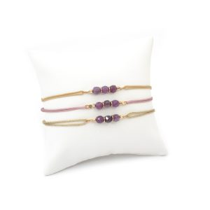 bracelets cordon avec trois pierres semi précieuses (rubis) présentés sur un coussin